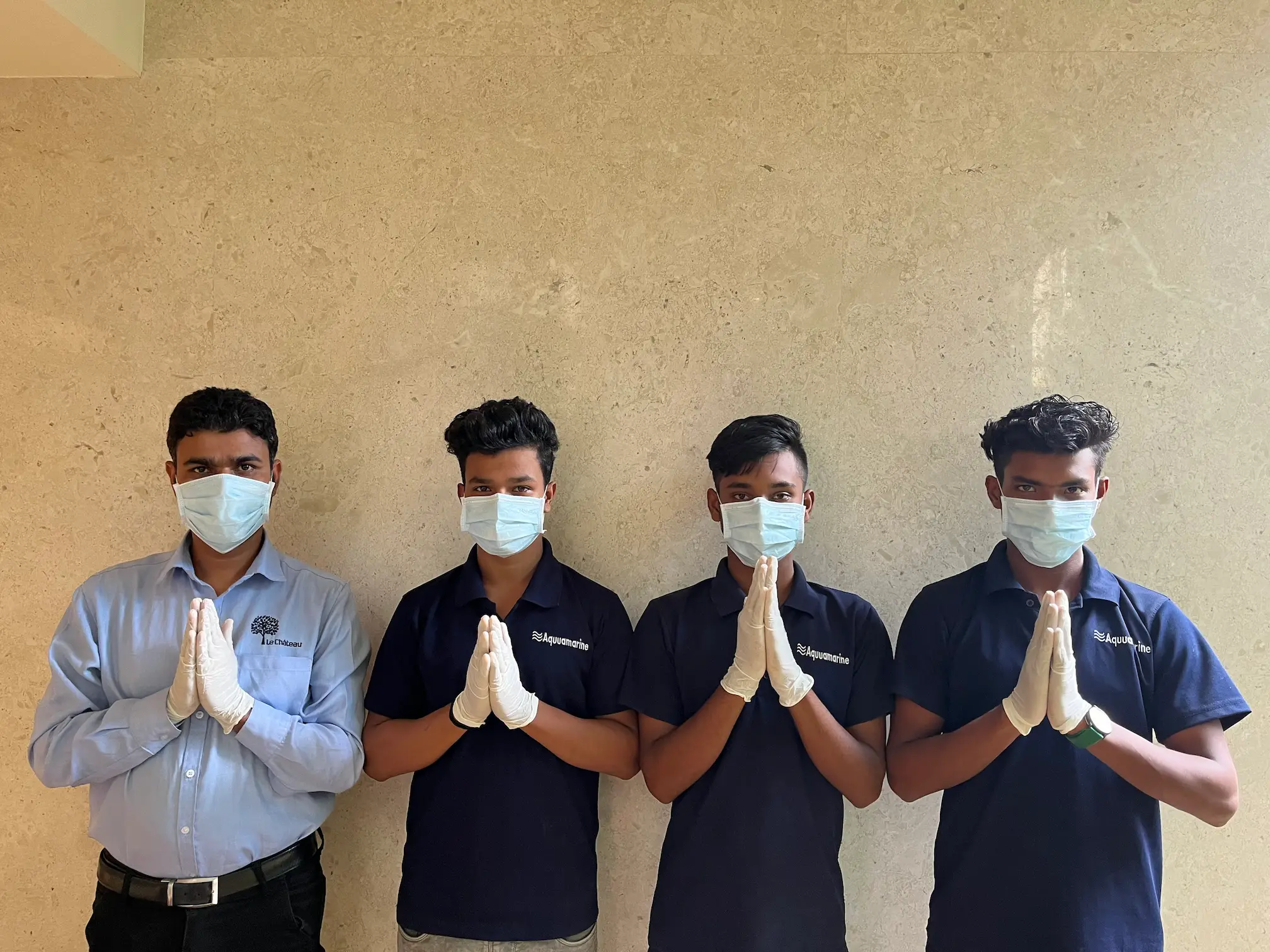 Housekeeping staff in masks and gloves greeting clients.